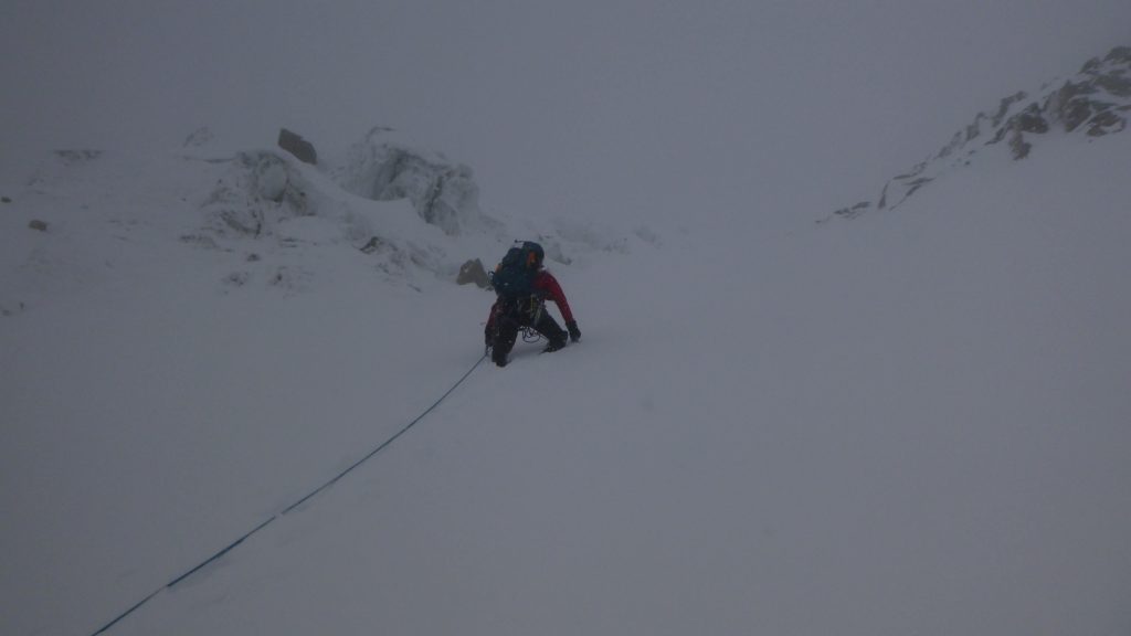 hegymászó ködben mászik a havas lejtőn